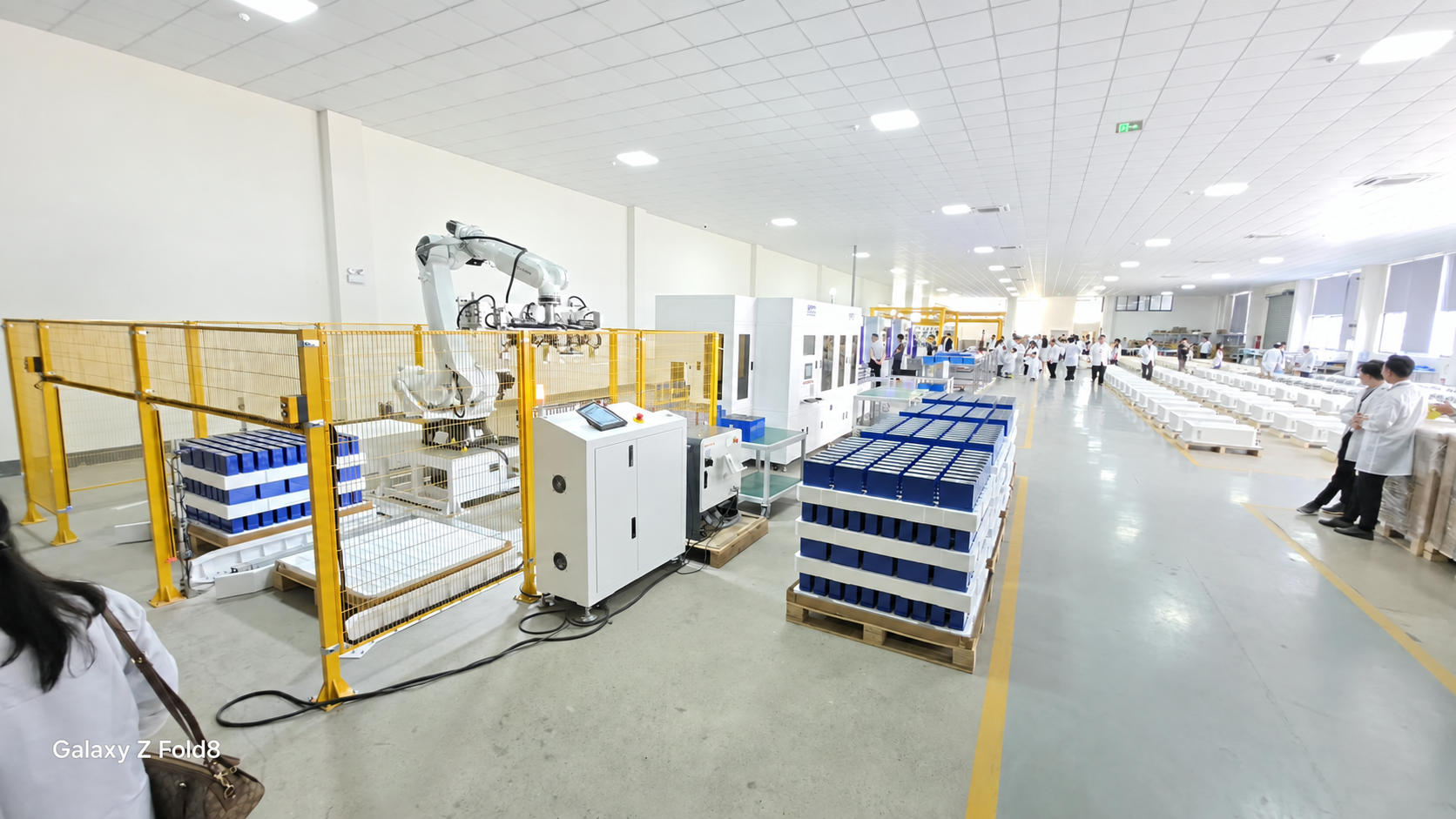 Khu vực xưởng trong chuyến tham quan nhà máy sản xuất pin lưu trữ APESS với robot và các khay cell pin.